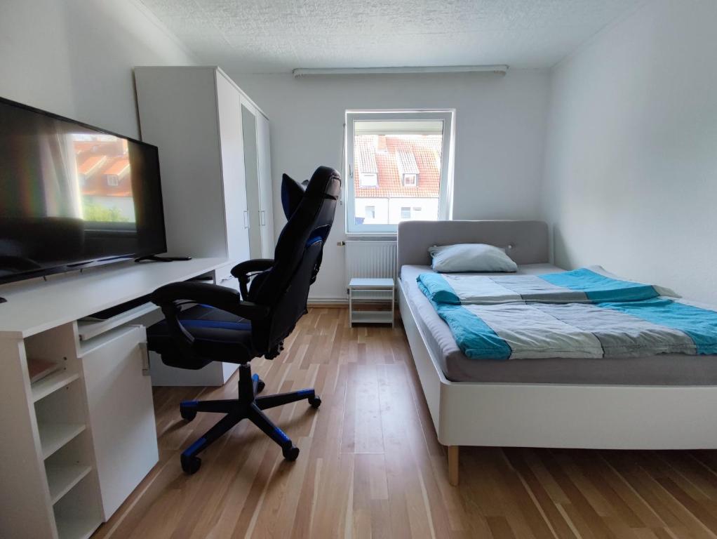 a bedroom with a bed and a desk and a chair at Messezimmer Hannover in Hannover