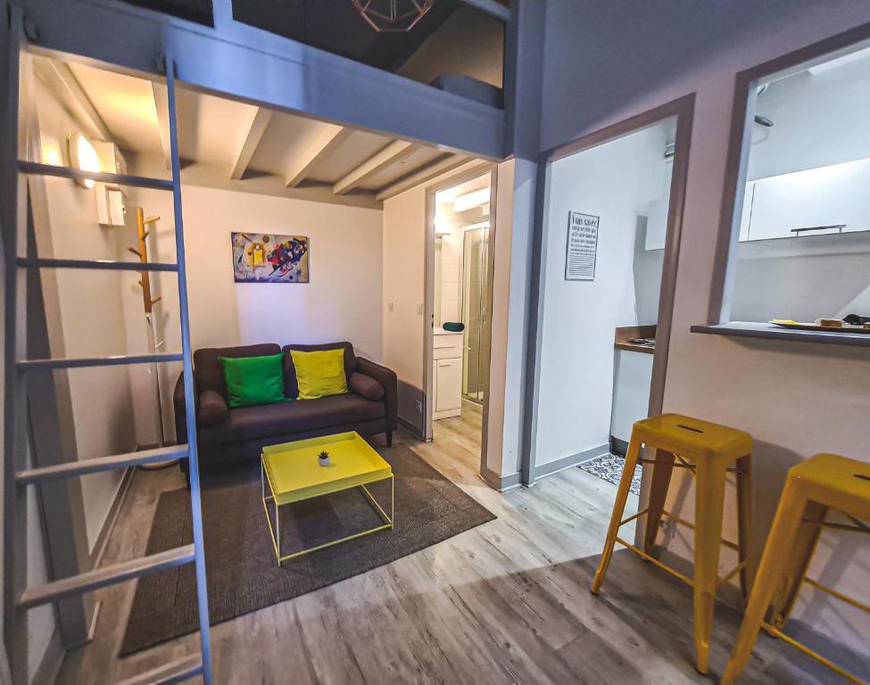 ein Wohnzimmer mit einem Sofa und einem Tisch in der Unterkunft Yellow Studio - Poitiers Coeur de ville in Poitiers
