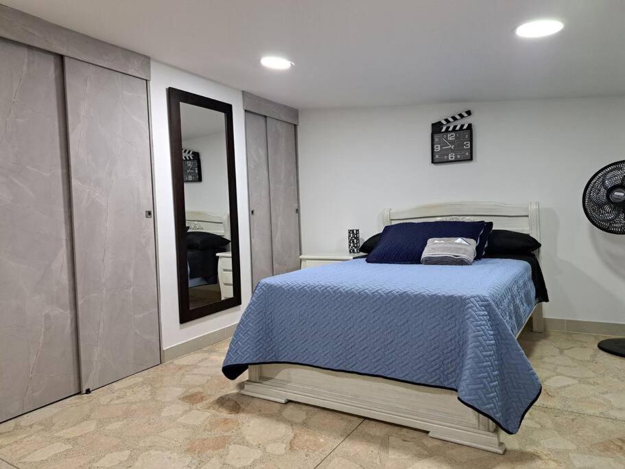 1 dormitorio con cama y espejo grande en Laureles 001, en Medellín