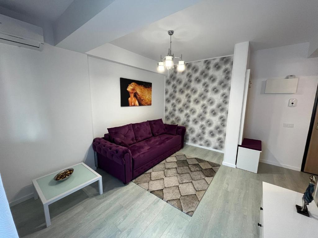 a living room with a purple couch and a table at Toscana Apartments in Otopeni