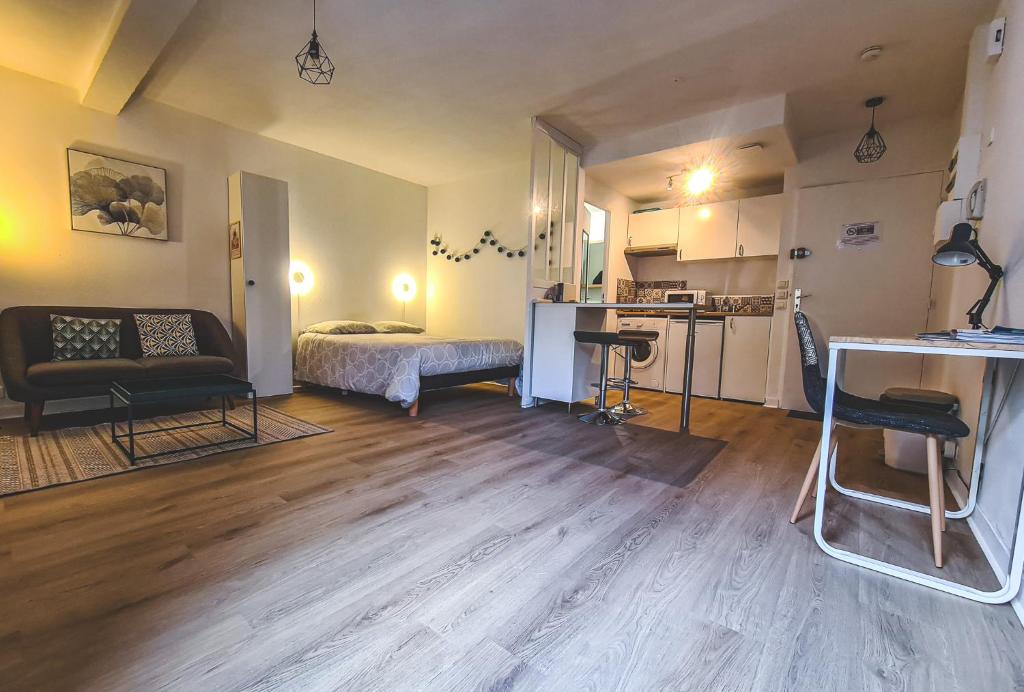 pequeña sala de estar con cama y cocina en Grand Studio neuf Parking Privatif 3 minutes Gare au calme en Poitiers