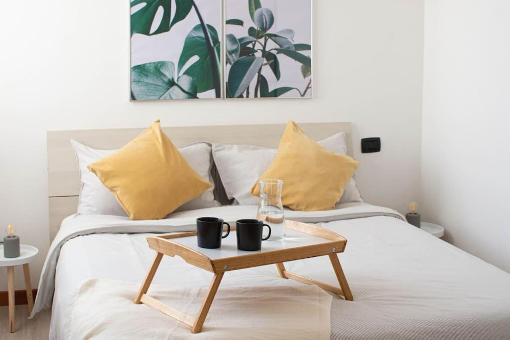 a coffee table sitting on a bed with yellow pillows at CA' GIALLA 2 - sul Lago di Lugano, self check-in e parcheggio - in Cadegliano Viconago