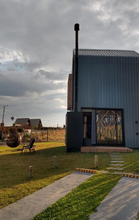 a blue building with a bench in a field at Tiny House Cambará in Cambará