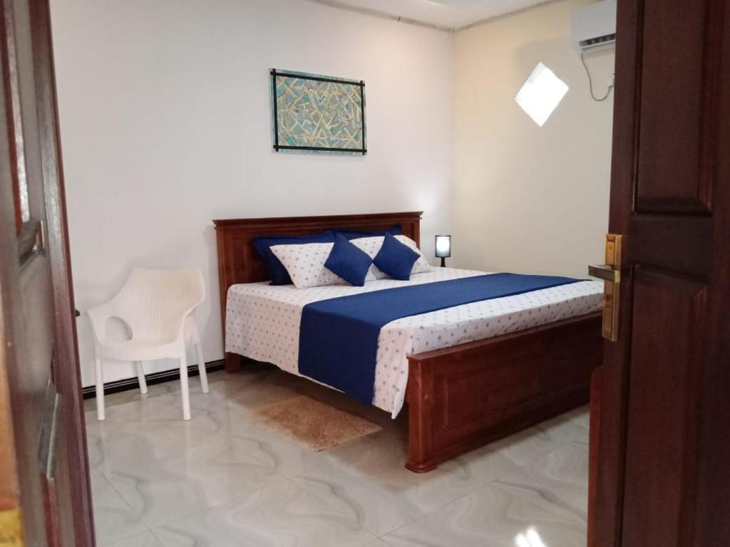um quarto com uma cama e uma cadeira em Friendly home stay em Etagama