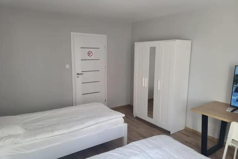 a bedroom with a bed and a dresser and a mirror at JR APARTMENT #4 - Slubice Center in Słubice