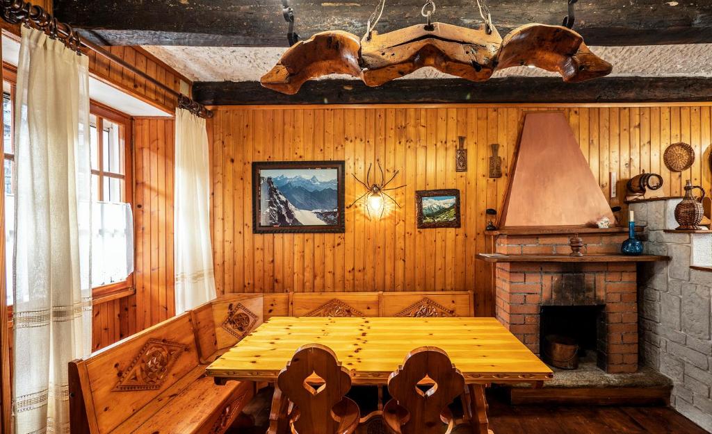 a dining room with a wooden table and a fireplace at Maison nonna Tilde - Valsusa in Mattie