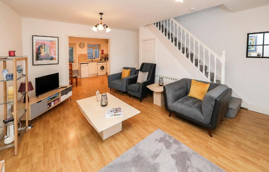 a living room with two chairs and a television at Two bedroom townhouse in the heart of Dungarvan in Dungarvan