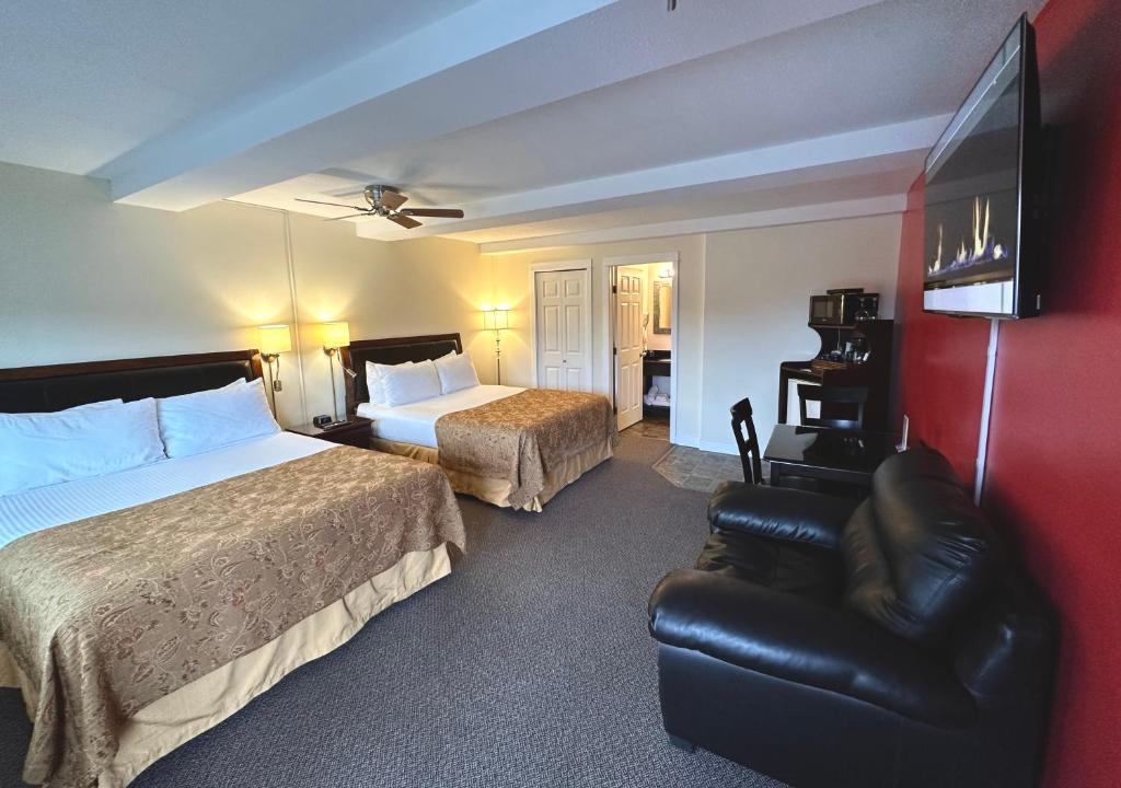 een hotelkamer met 2 bedden en een leren stoel bij Bayshore Waterfront Inn in Ucluelet