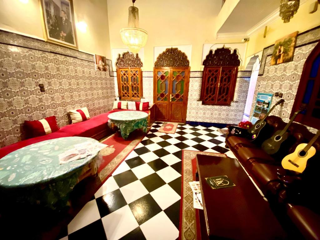 ein Wohnzimmer mit einem karierten Boden und ein Zimmer mit einer Gitarre in der Unterkunft Riad Fattouma Kasba in Marrakesch