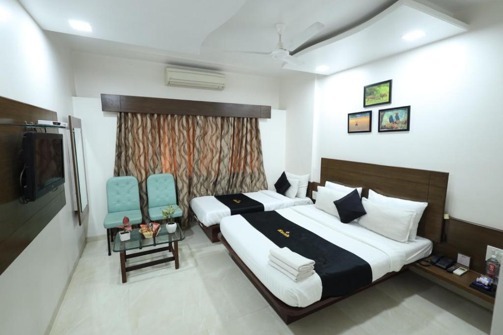 Postel nebo postele na pokoji v ubytování Saish Hotel Shirdi