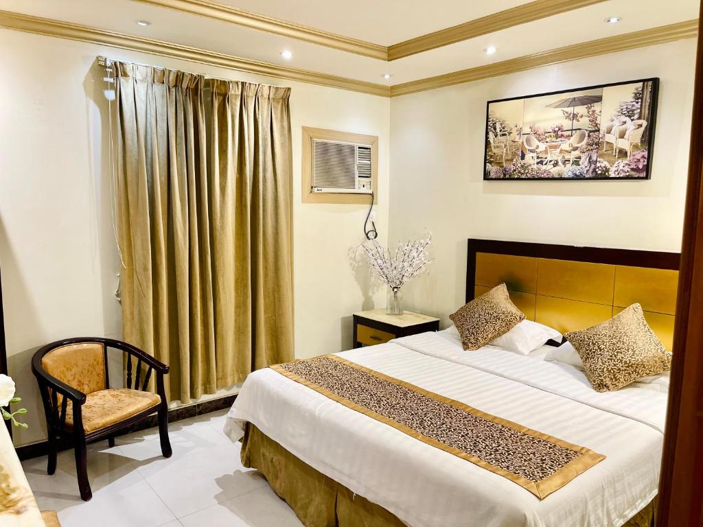 1 dormitorio con 1 cama grande y 1 silla en Diamond Tower en Al Jubail