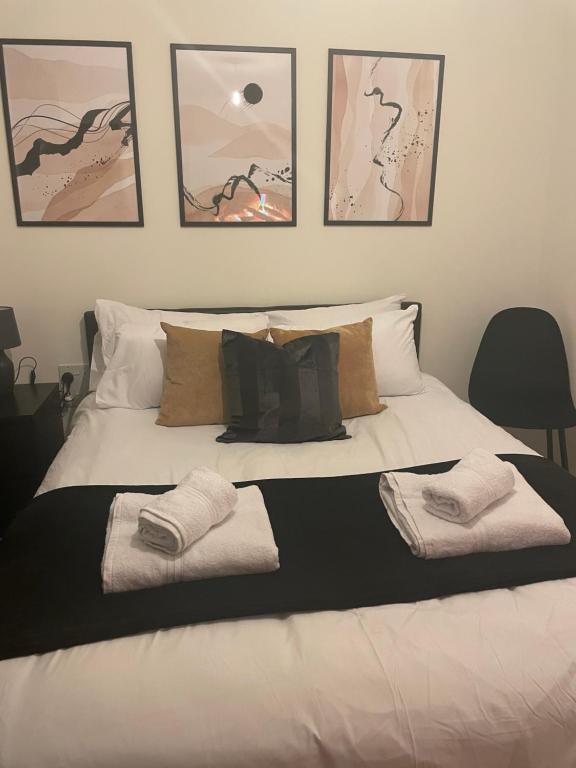 ein weißes Bett mit drei Handtüchern darüber in der Unterkunft Great 1Bed 10 mins from East Croydon with Free parking in Croydon