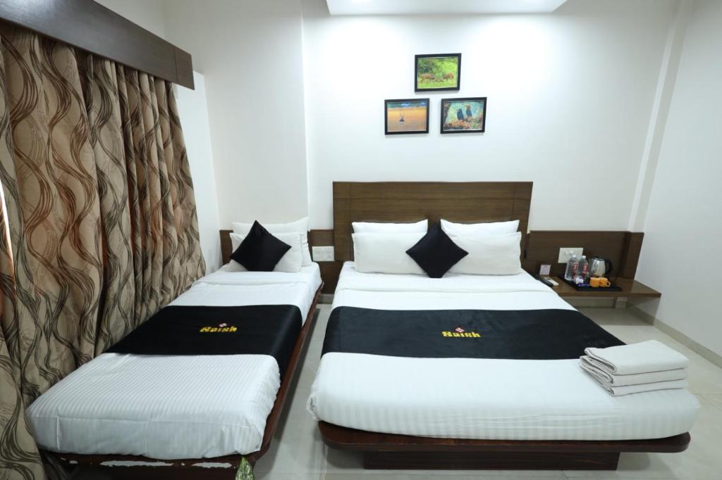 Postel nebo postele na pokoji v ubytování Saish Hotel Shirdi