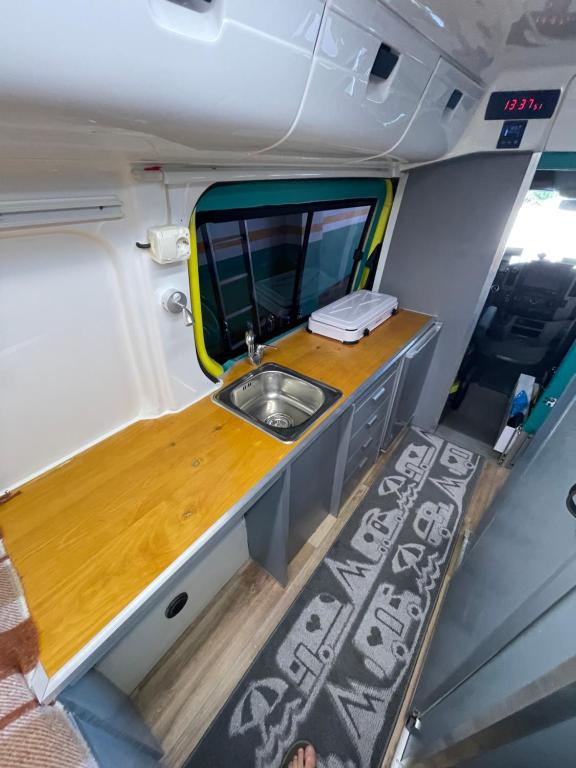 a kitchen with a sink and a mirror in an rv at Autocaravana in Puerto de Sagunto