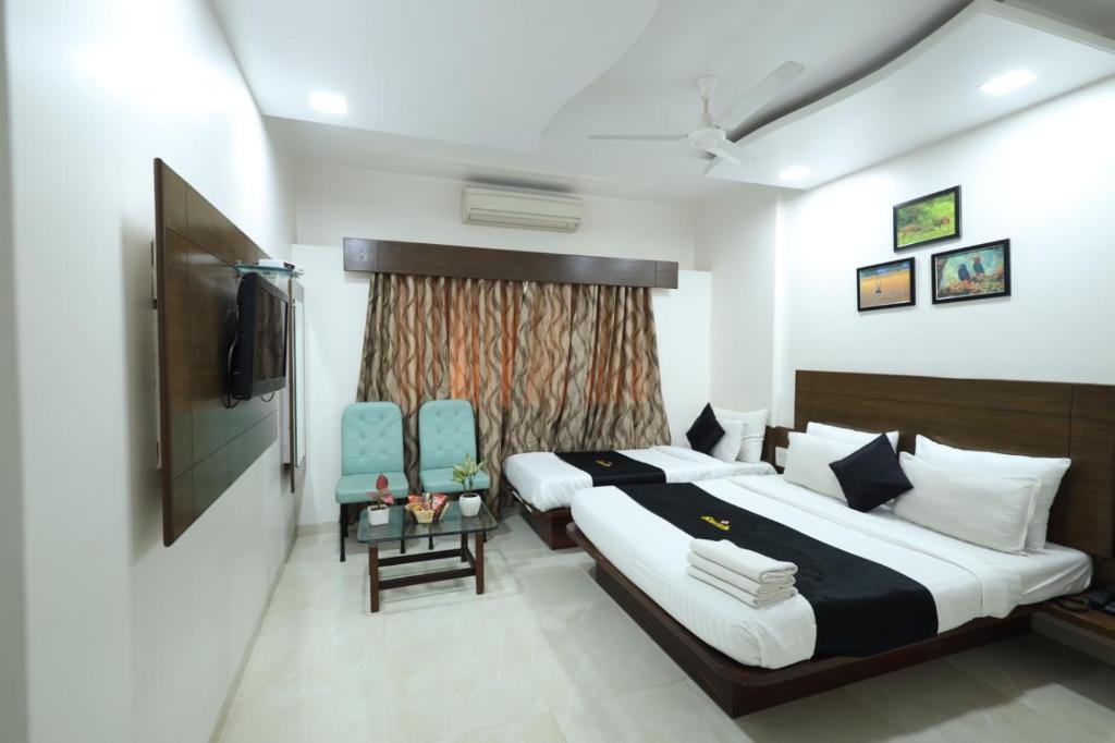 Postel nebo postele na pokoji v ubytování Saish Hotel Shirdi