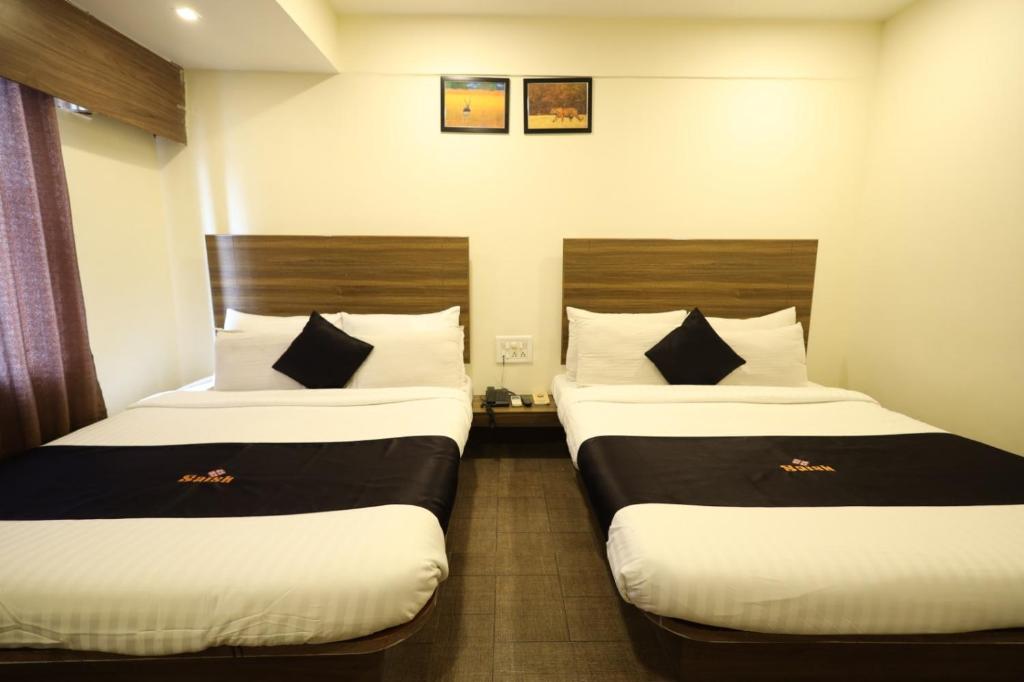 Postel nebo postele na pokoji v ubytování Saish Hotel Shirdi