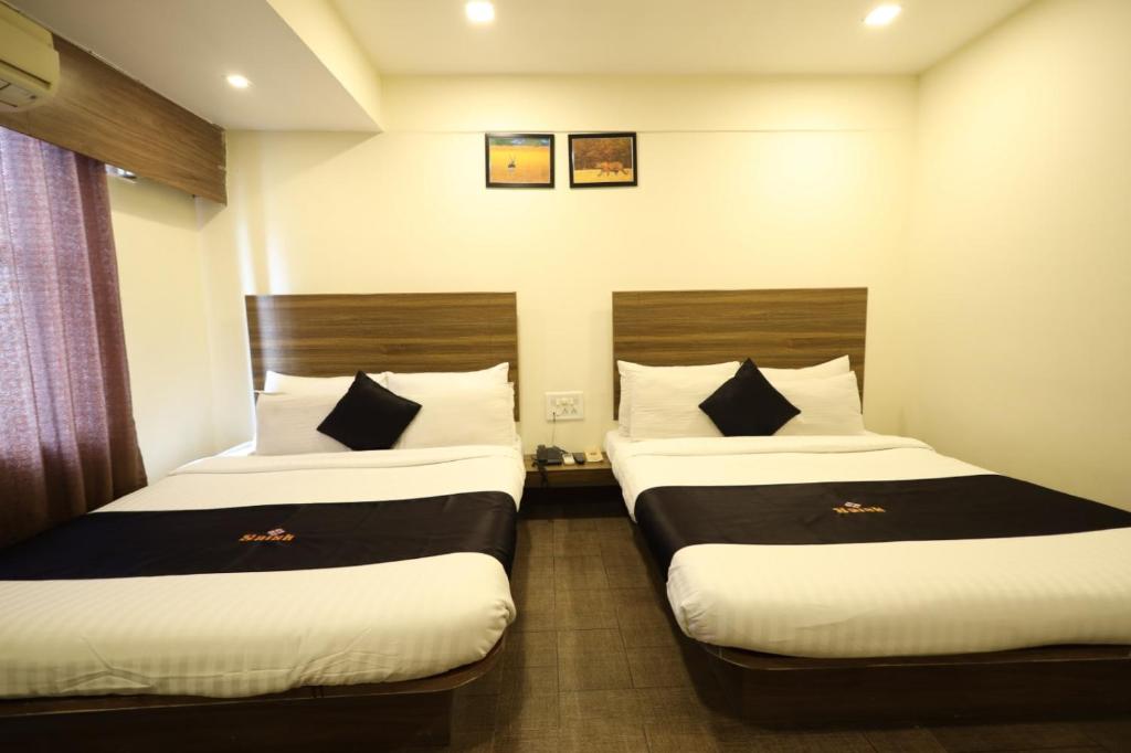 Postel nebo postele na pokoji v ubytování Saish Hotel Shirdi
