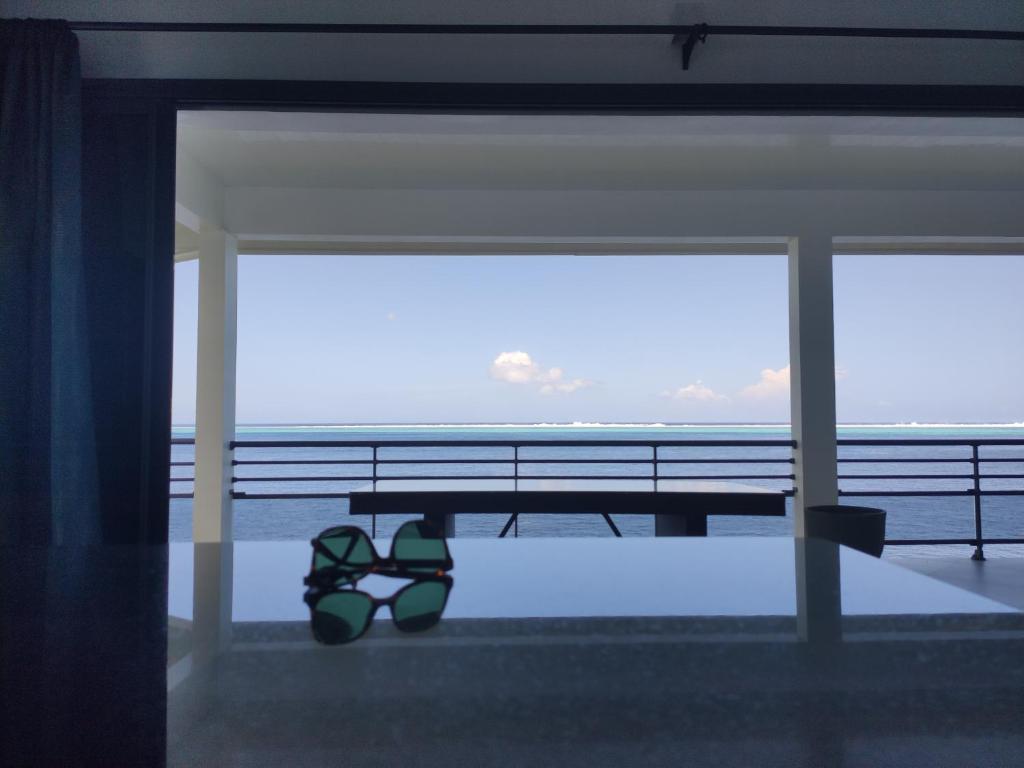 une paire de lunettes assise sous un banc près de l'océan dans l'établissement Villa MATOANUI, à Tevaitoa