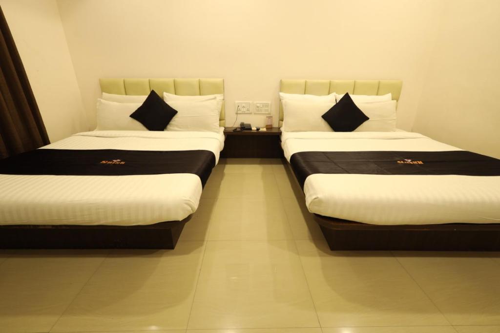 Postel nebo postele na pokoji v ubytování Saish Hotel Shirdi