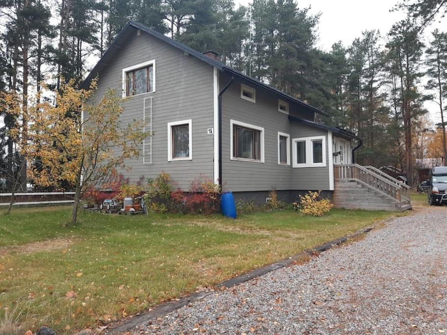 a gray house with a driveway in front of it at Omakotitalo ykspihlajassa 110m2 in Kokkola