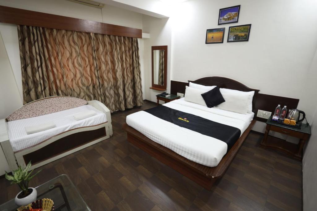Postel nebo postele na pokoji v ubytování Saish Hotel Shirdi