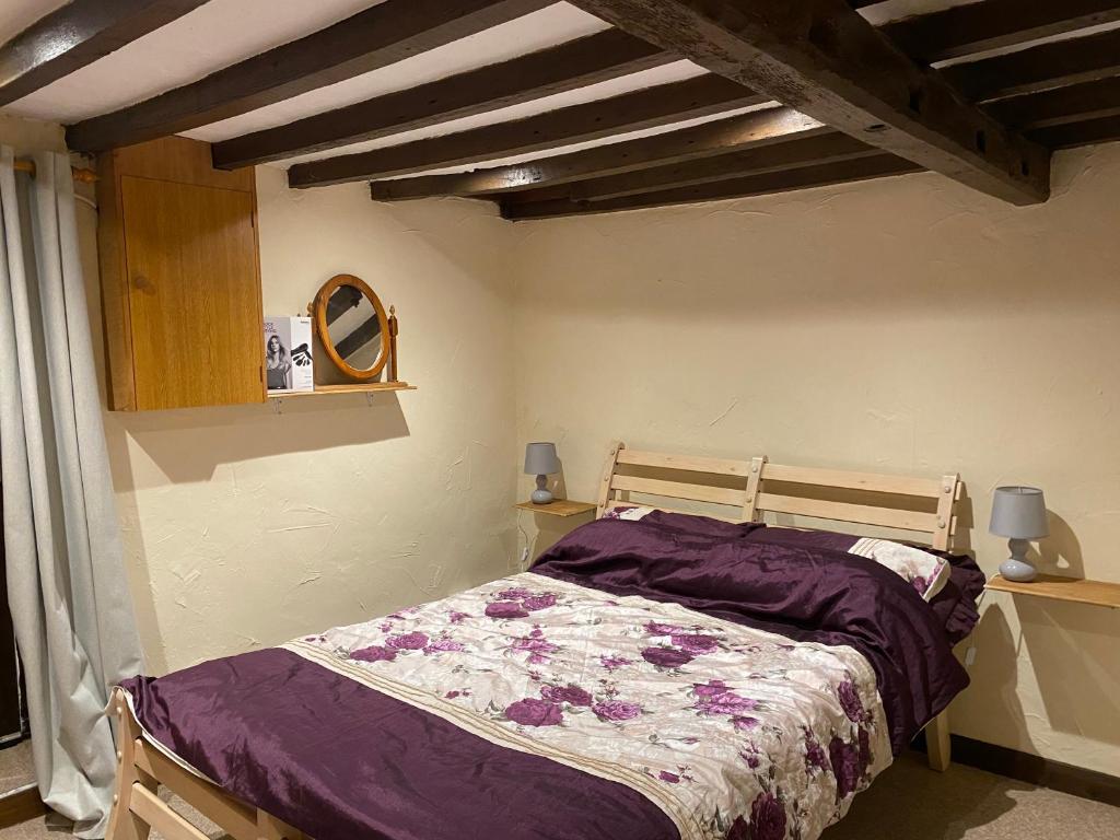 a bedroom with a bed with a purple comforter at The Barn at Providence Cottage in Alkborough