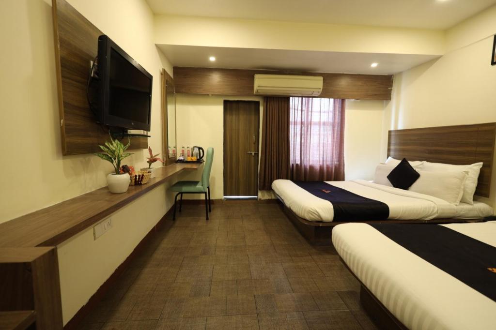 Postel nebo postele na pokoji v ubytování Saish Hotel Shirdi