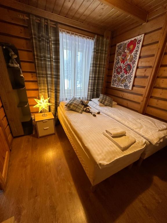 a bedroom with a bed in a wooden room at Osada Barbanica in Szczyrk