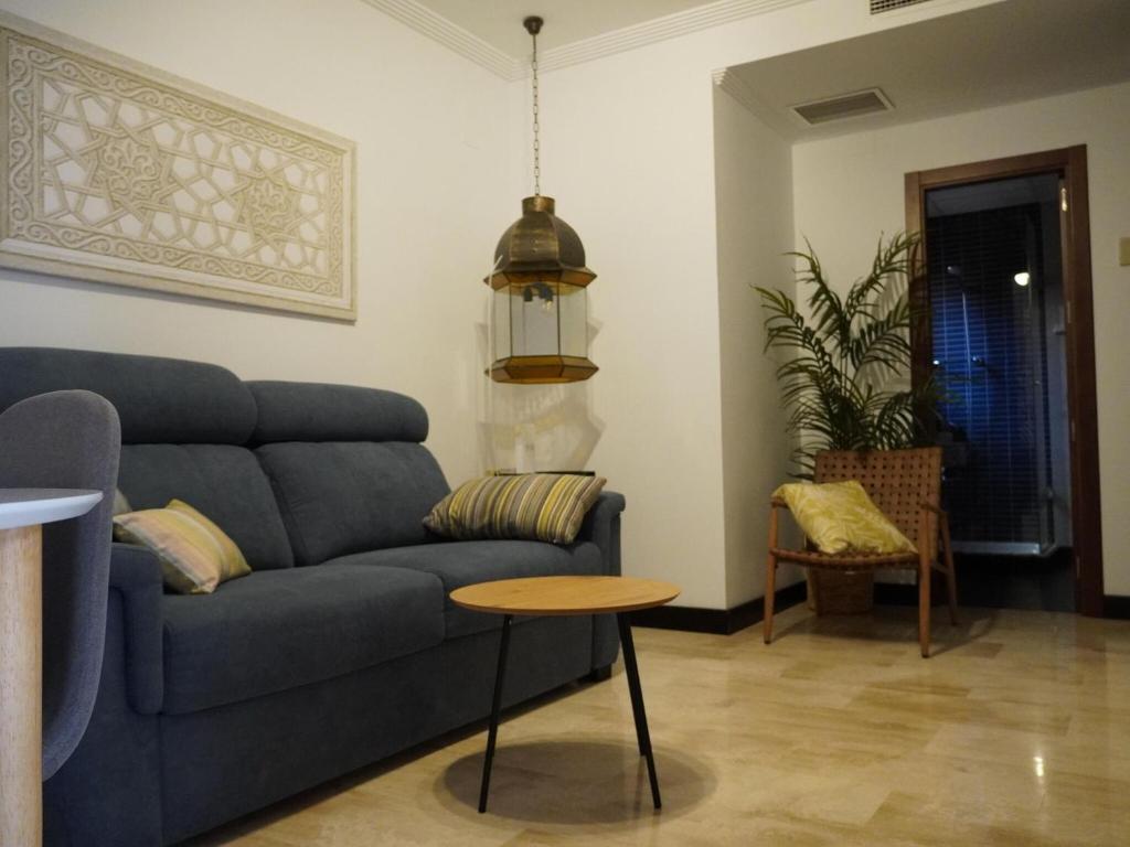 a living room with a blue couch and a table at Cozy holiday home in a charming area in Montilla