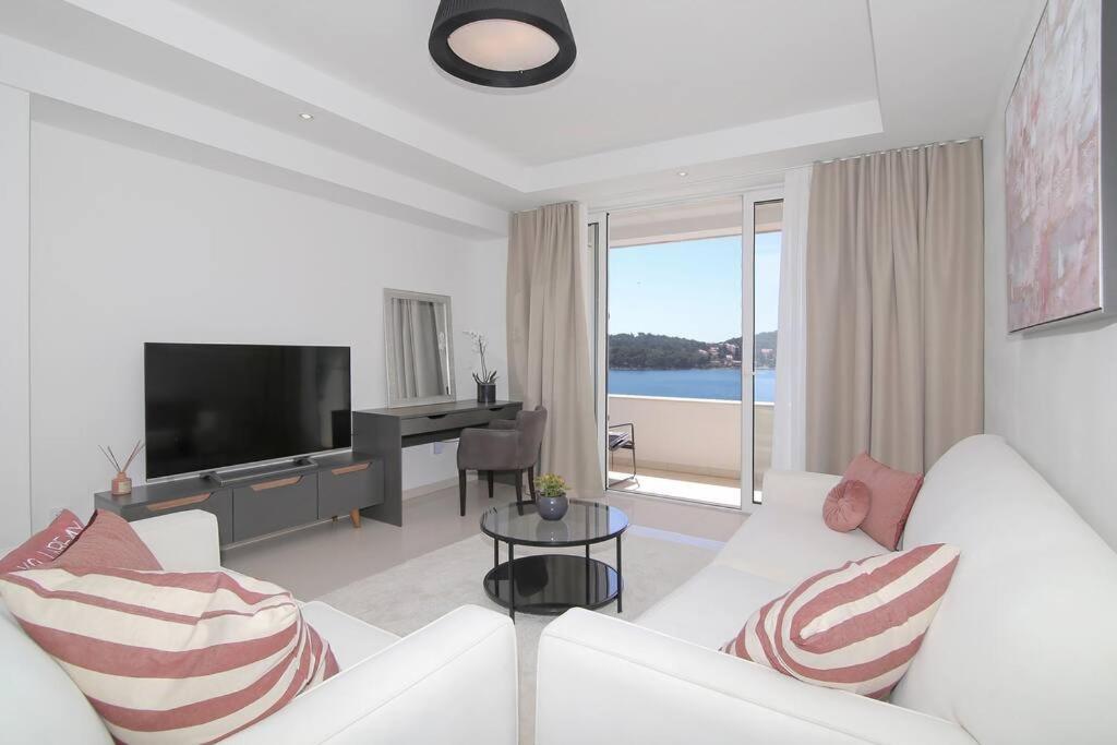 a living room with a white couch and a television at Seaside Apartment M Zaton 5 - Sea View & Parking in Zaton