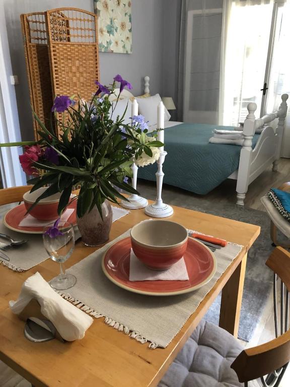a table with plates and a bowl on top of it at MeadowView Spacious renovated ground floor studio in Análipsis