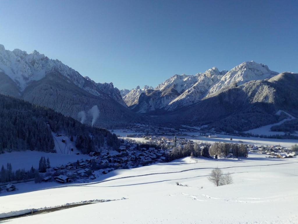 a snow covered mountain range with a town in a valley at Gostnerhof in Dobbiaco