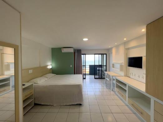 1 dormitorio con 1 cama y TV en PARADISE FLAT NATAL APT. 405, en Natal