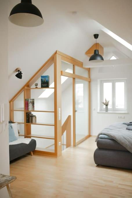 a living room with a bed and a stair case at Jules Ferienhaus im Allgäu mit Garten in Willofs