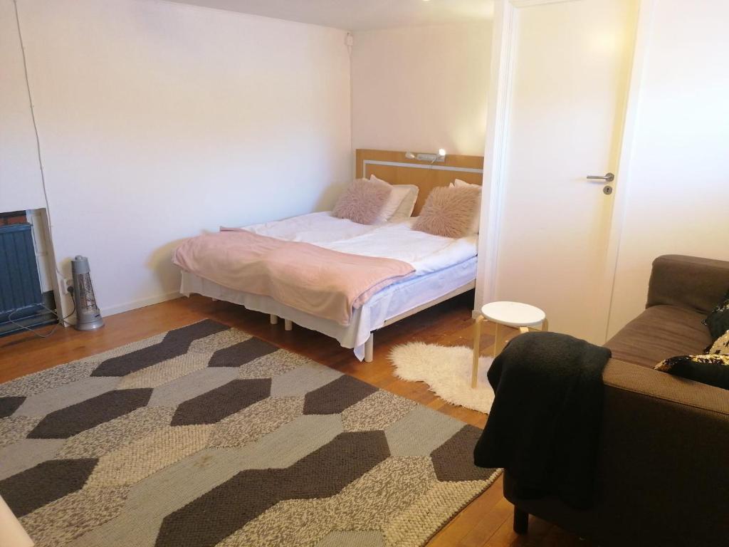 Dormitorio pequeño con cama y alfombra en Ett rums lägenhet med egen ingång, parkering en Örebro