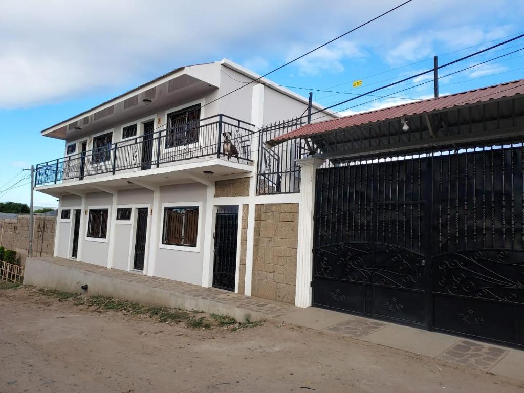 a white house with a balcony and a gate at Wally’s Place in Estelí