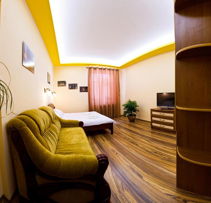 a room with a couch and a bed and a tv at Apartments "The cultural capital" in Lviv