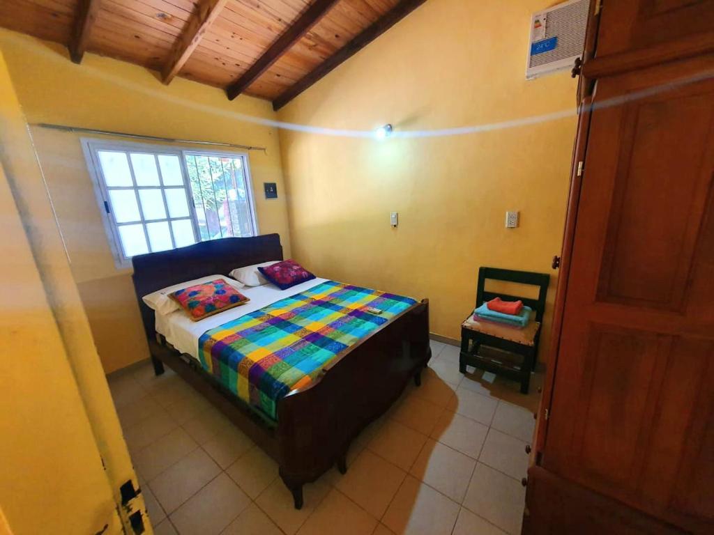 Habitación pequeña con cama y ventana en Ara Vera en Empedrado