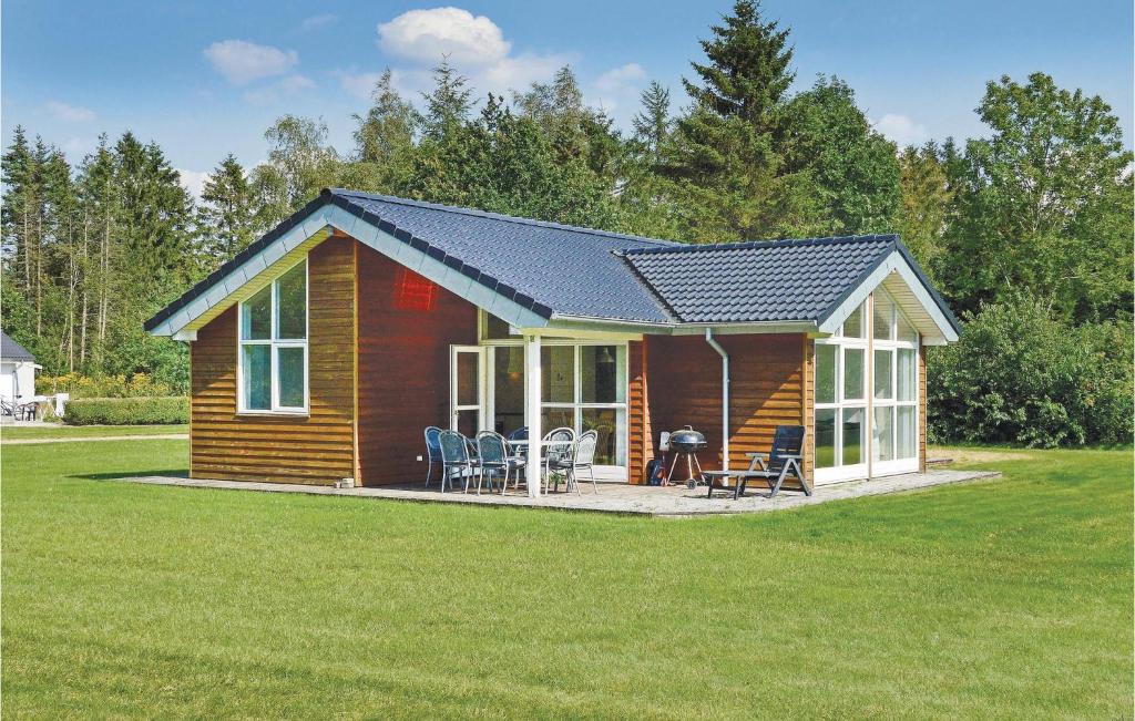 a log cabin with a pitched roof on a lawn at Holiday Home Lyngshuse Herning Iv in Kølkær
