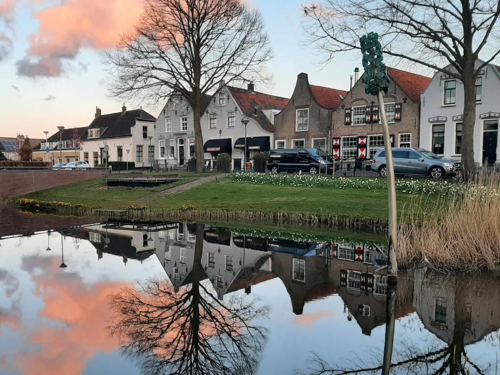 a reflection of a building in a body of water at B&B de Hartewens in Zuidland