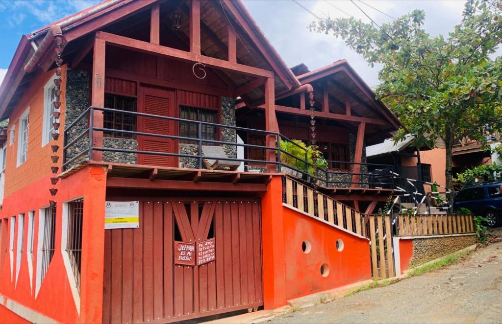 an orange building with a balcony on a street at Primavera en Jarabacoa-contacto con la naturaleza in Jarabacoa