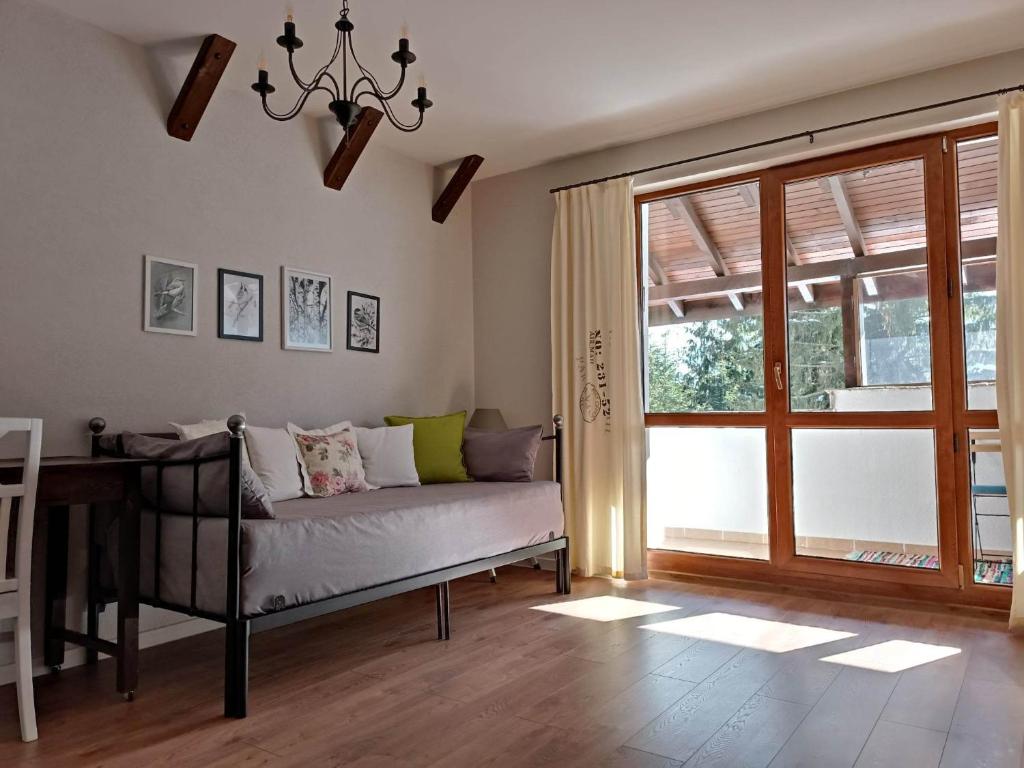 a living room with a couch and a window at Студио "Птича Песен" - Studio "Birdsong", Смолянски езера in Smolyan