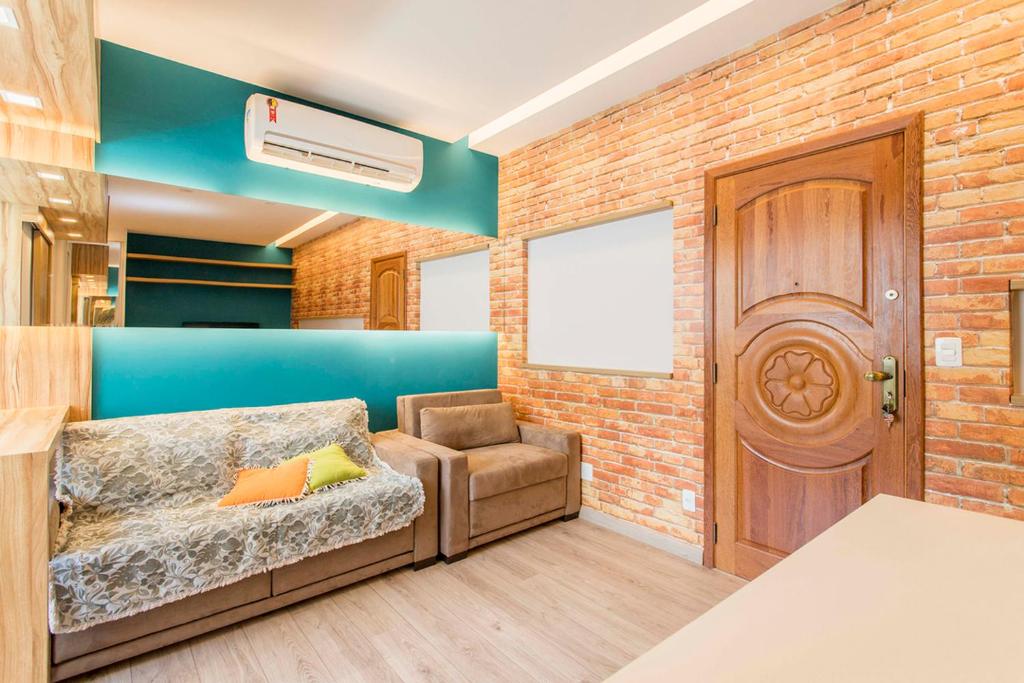 Habitación con sofá, silla y puerta en Otimo loft c WiFi a 500m da Praia de Copacabana RJ, en Río de Janeiro