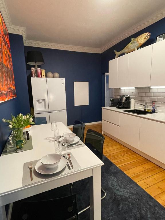 una cocina con una mesa con platos. en Luxus Altbaucharme in zentraler Lage, en Kiel