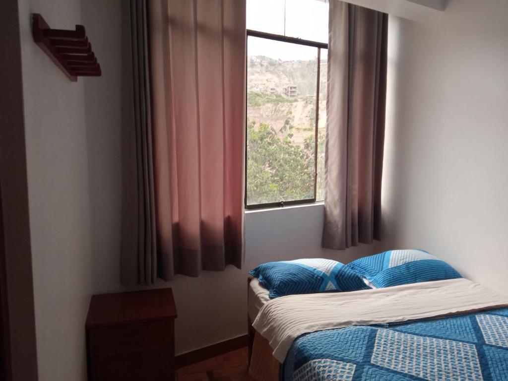 1 dormitorio con 2 camas y ventana en HOSTAL EL CARIBE, en Ayacucho
