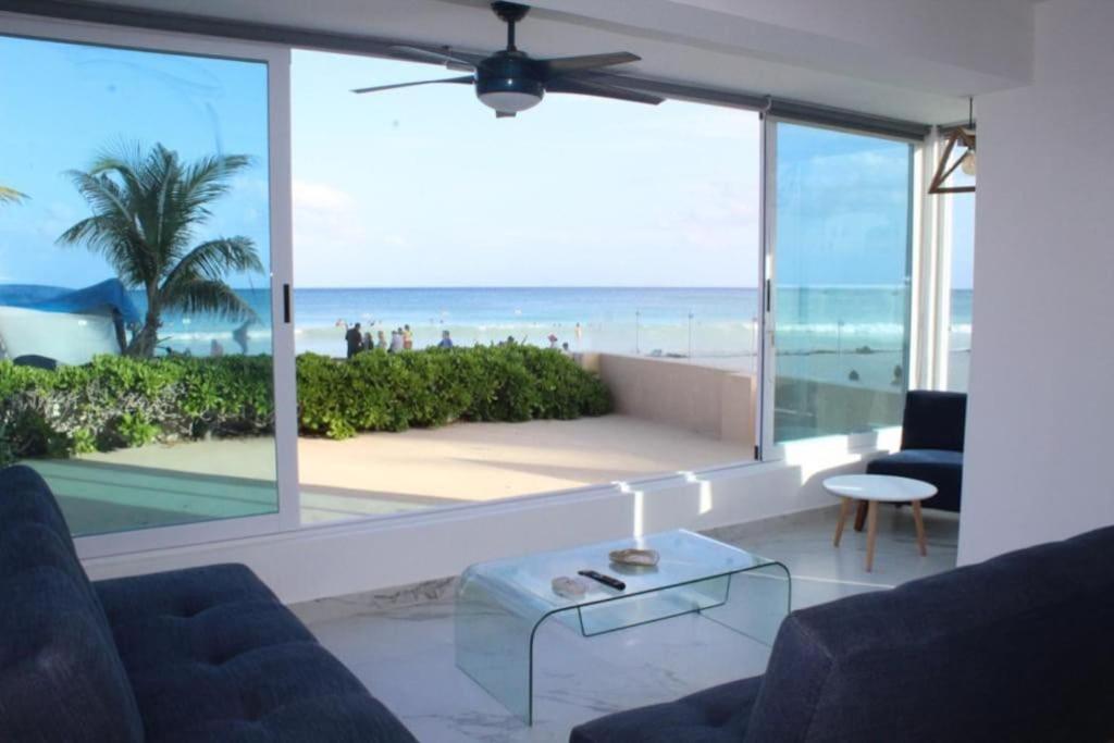 a living room with a view of the beach at Beach Front Renewed Apartment in Cancún