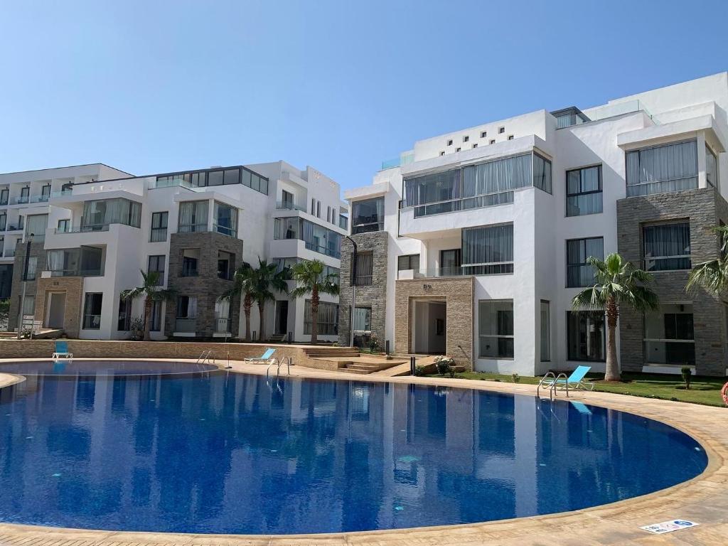 a large swimming pool in front of some buildings at Très haut standing piscine, plage + Netflix in Agadir