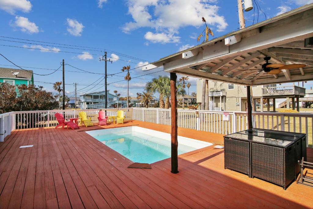 una terraza con piscina y sombrilla en The Happy Clam, en Galveston
