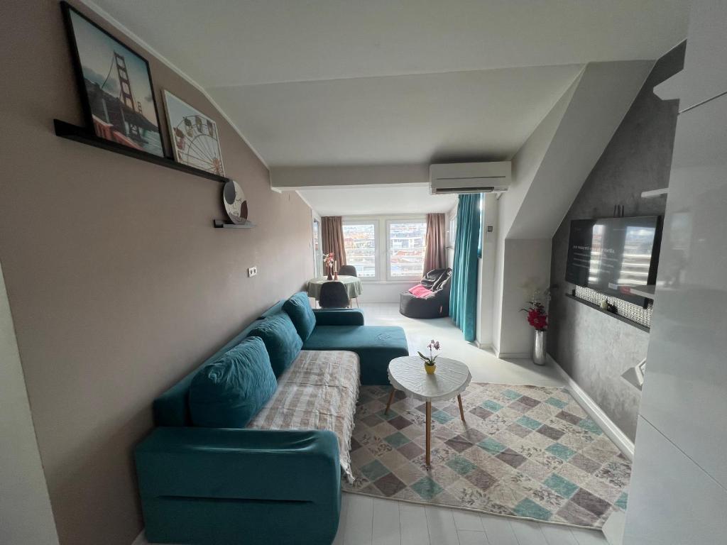 a living room with a blue couch and a table at Town Place Apartment in Kŭrdzhali