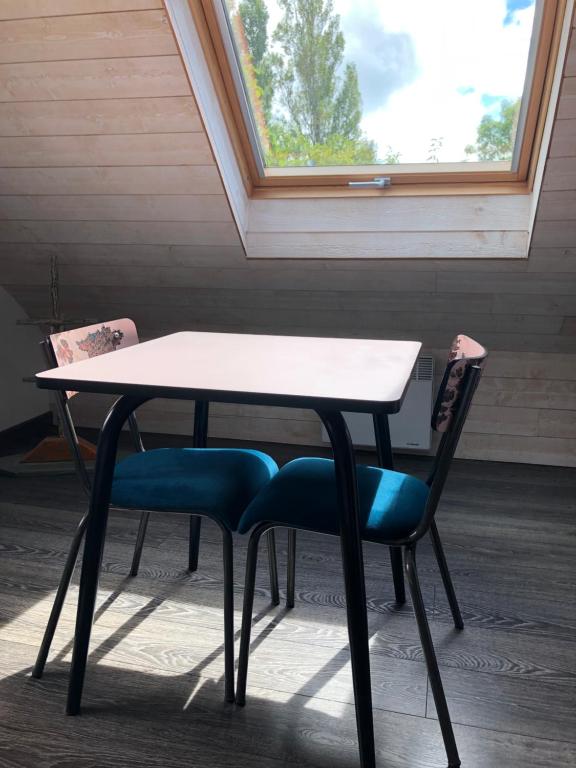 a table and two chairs in front of a window at Les Chambres d&#39;Hôtes de Bordustard in Le Palais